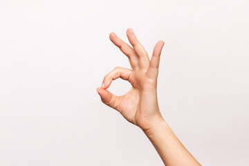 Female hand showing the ok gesture isolated on a white background. Okey hand sign